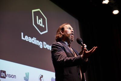 The author of this article (Andy Budd) is on stage, speaking at the Leading Design conference. The Leading Design logo is behind him